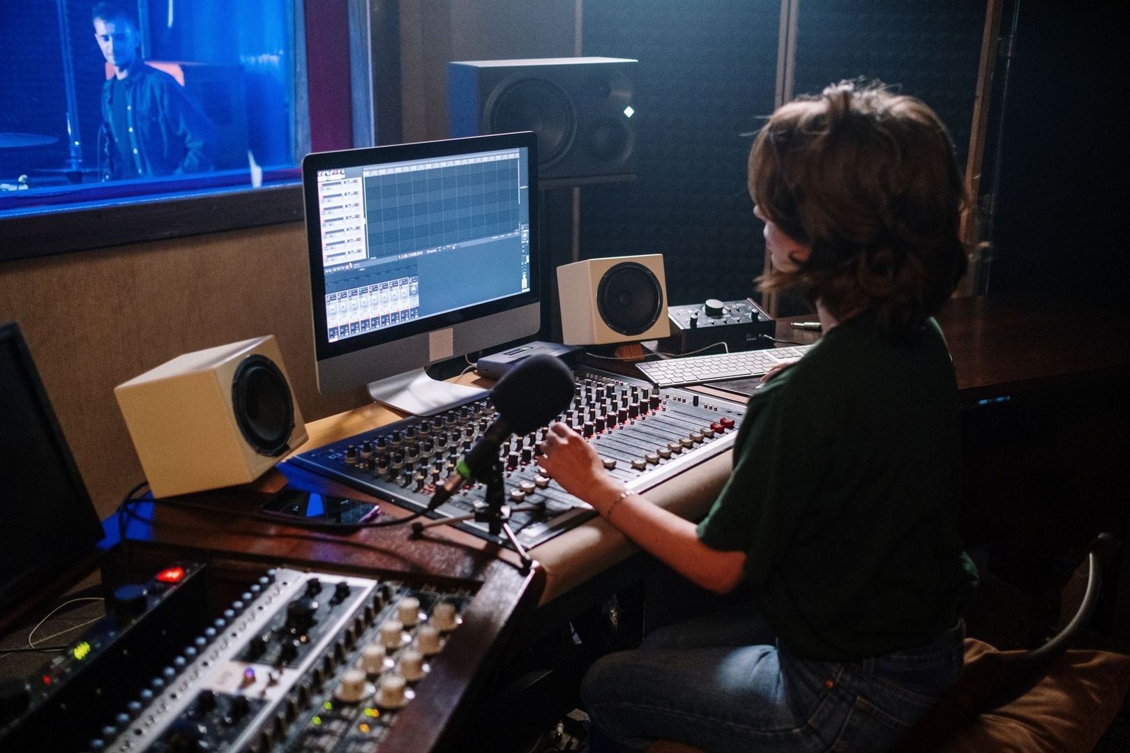 Audio engineer operating a mixing console in a recording studio